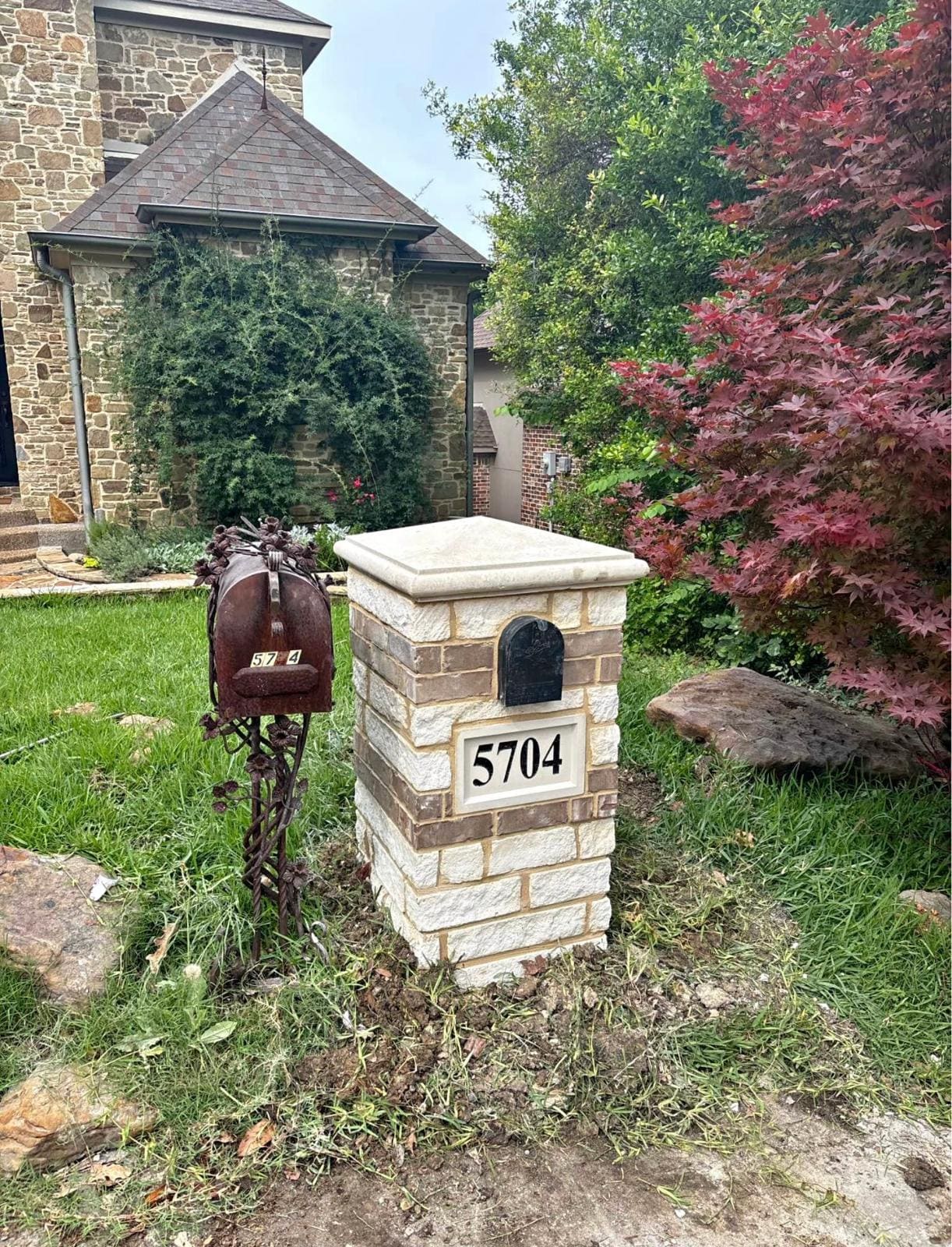 Coursed stone pillar mailbox with a set address plaque