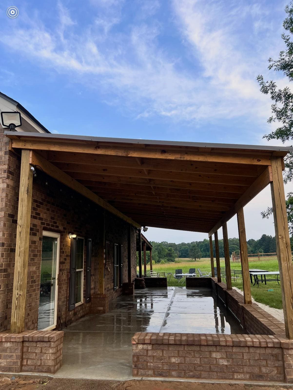 Covered patio with brick piers, a timber ceiling and a poured concrete slab